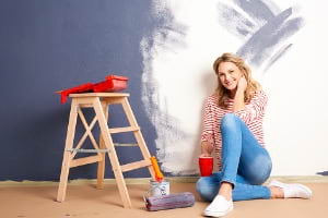 Adult woman sitting in home next to ladder